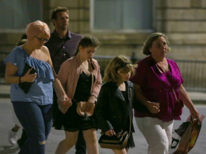 MANCHESTER, ENGLAND - MAY 23: Members of the public are escorted from the Manchester Arena on May 23, 2017 in Manchester, England. An explosion occurred at Manchester Arena as concert goers were leaving the venue after Ariana Grande had performed. Greater Manchester Police have confirmed 19 fatalities and at least …