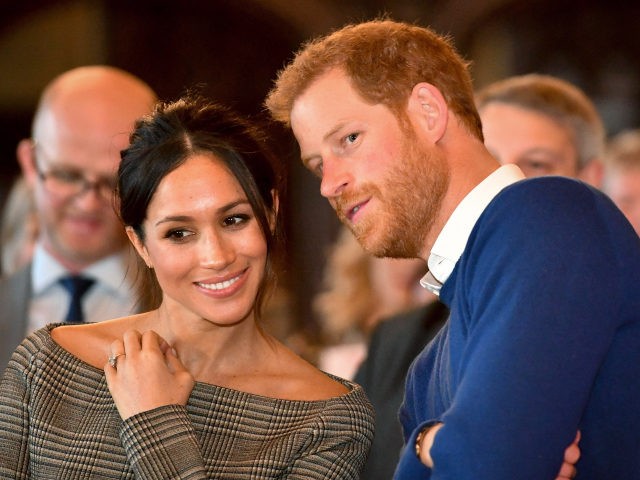 CARDIFF, WALES - JANUARY 18: Prince Harry whispers to Meghan Markle as they watch a dance