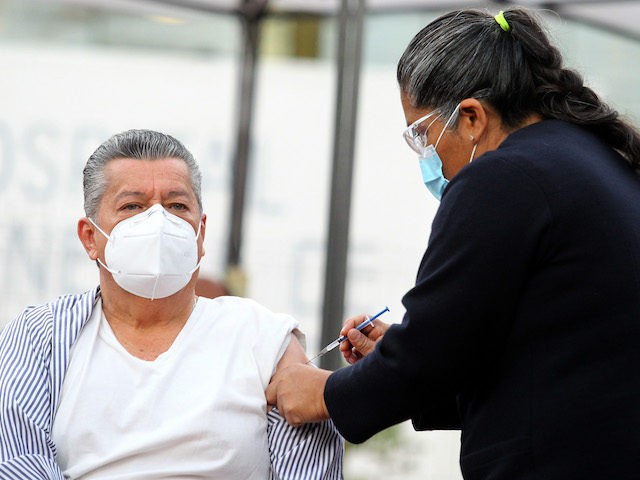 A nurse administrates a Pfizer-BioNTech Covid-19 vaccine to 66-years-old epidemiological doctor David Diaz Santana, during the start of vaccination against the SARS-CoV-2 virus to medical personnel of the General Hospital of the West Zoquipan in Zapopan, Jalisco state, Mexico, on January 13, 2021. (Ulises Ruiz/AFP via Getty Images)