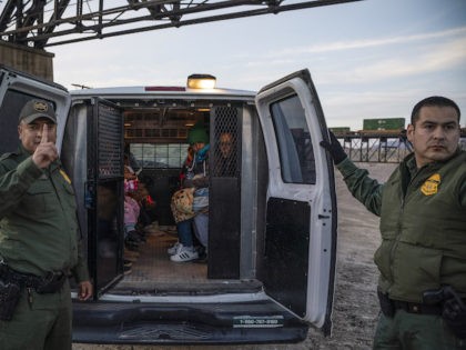 In this file photo, a group of about 30 Brazilian migrants, who had just crossed the border, get into a US Border Patrol van, taking them off the property of Jeff Allen, who used to run a brick factory near Mt. Christo Rey on the US-Mexico border in Sunland Park, …