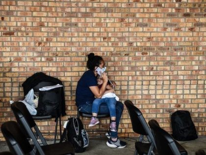 A migrant girl from Central America waits with her mother for a bus after they are dropped off by the US Customs and Border Protection at a bus station near the Gateway International Bridge, between the cities of Brownsville, Texas, and Matamoros, Mexico, on March 15, 2021 in Brownsville, Texas. …