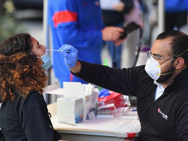 A medical worker takes a nasal swab sample from a student to test for COVID-19 at the Brooklyn Health Medical Alliance urgent care pop up testing site as infection rates spike on October 8, 2020 in New York City. - New York's governor announced earlier in the week tough new …