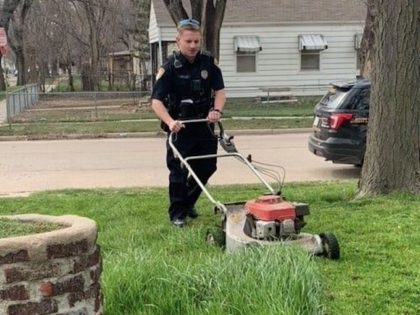 Officer Wells mows a lawn.