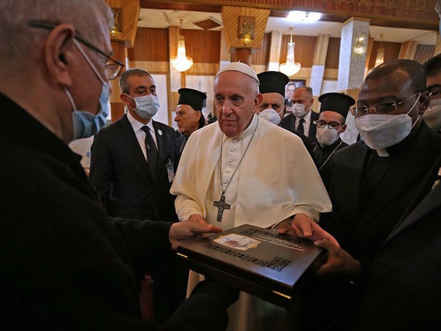 Pope Francis receives a gift during his visit to the Syro-Catholic Cathedral of Our Lady o