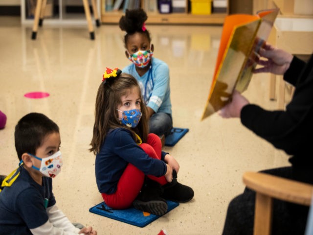Pre-kindergarten students listen as their teacher reads a story at Dawes Elementary in Chicago, Monday, Jan. 11, 2021. Chicago Public Schools students began their return to the classroom Monday as school doors opened to thousands of pre-kindergarten and some special education students after going remote last March due to the …