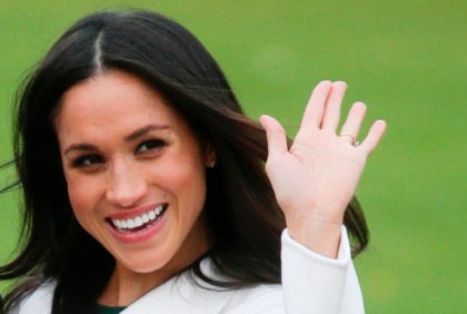 Britain's Prince Harry's fiancee US actress Meghan Markle waves as she poses for a photograph in the Sunken Garden at Kensington Palace in west London on November 27, 2017, following the announcement of their engagement. - Britain's Prince Harry will marry his US actress girlfriend Meghan Markle early next year …