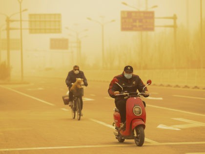 People wearing protective masks ride their bikes along a street during a sandstorm on March 15, 2021 in Beijing, China. The Chinese capital and the northern parts of the country was hit with a sandstorm on Monday, sending air quality indexes of PM 2.5 and PM 10 ratings into the …