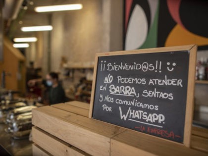 A banner reading in Spanish: "Welcome, we cannot serve in the bar. Sit down and we communi