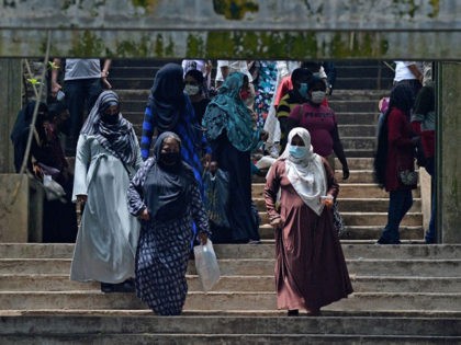 Burqa clad Muslim women climb down a flight of stairs at a zoological park on the outskirt