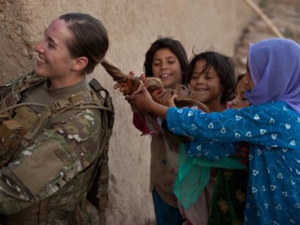 Women in the U.S. Army will be allowed to wear ponytails -- like that of U.S. Army Sgt. Janean Sanders, pictured letting a group of Afghan girls in Kandahar play with her hair -- with uniforms other than those for exercise or combat. Photo by Sgt. Canaan Radcliffe/DVIDS