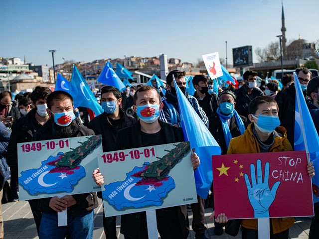 Members of the Muslim Uighur minority hold placards as they demonstrate to ask for news of