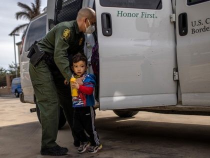 BROWNSVILLE, TEXAS - FEBRUARY 26: A U.S. Border Patrol agent delivers a young asylum seeker and his family to a bus station on February 26, 2021 in Brownsville, Texas. U.S. immigration authorities are now releasing many asylum seeking families after detaining them while crossing the U.S.-Mexico border. The immigrant families …