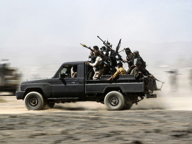 Armed Yemeni tribesmen loyal to the Shiite Huthi rebels sit in the back of an armed vehicl