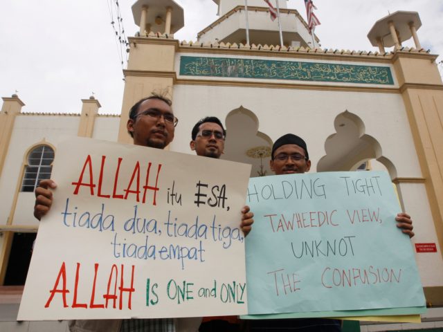Muslims hold placards up outside a mosque following Friday prayers in central Kuala Lumpur