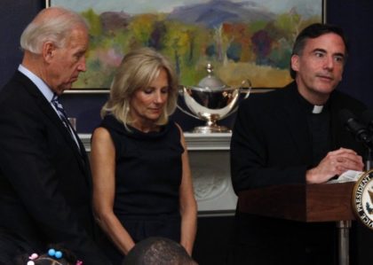FILE - In this Nov. 22, 2010, file photo, Vice President Joe Biden, left, and his wife, Jill Biden, center, stand with heads bowed as the Rev. Kevin O'Brien says the blessing during a Thanksgiving meal for Wounded Warriors in Washington. O'Brien, the Jesuit priest who presided over an inaugural …