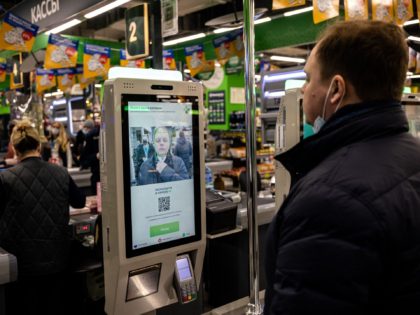 An X5 group representative demonstrates a facial recognition payment system at a self-chec