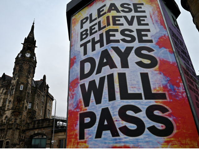 GLASGOW, SCOTLAND - APRIL 09: Members of the public walk past new posters placed around th