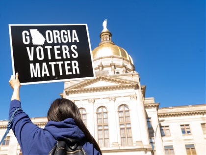 ATLANTA, GA - MARCH 03: Demonstrators stand outside of the Georgia Capitol building, to oppose the HB 531 bill on March 3, 2021 in Atlanta, Georgia. HB 531 will add controversial voting restrictions to the state's upcoming elections including restricting ballot drop boxes, requiring an ID requirement for absentee voting …