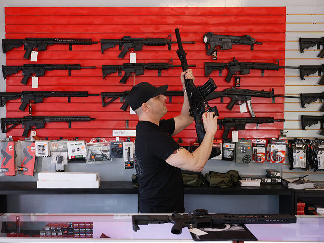 DELRAY BEACH, FLORIDA - MARCH 24: Brandon Wexler helps a customer look at weapons at WEX G