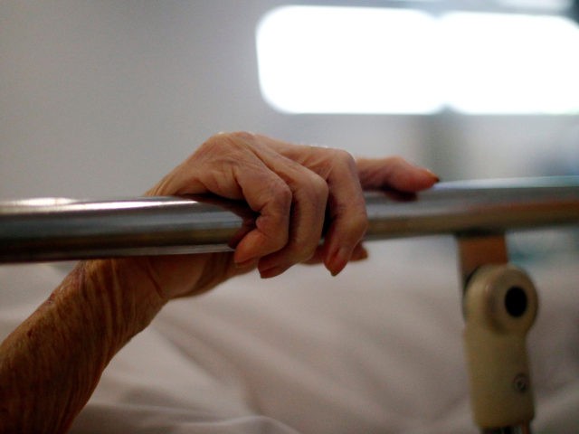 The hand of a patient grips the rail of a hospital bed in the X-ray department at the Royal Blackburn Teaching Hospital in Blackburn, north-west England on May 14, 2020, as national health service (NHS) staff in Britain fight the novel coronavirus COVID-19 pandemic. (Photo by HANNAH MCKAY / POOL …