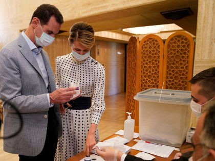 FILE - This file photo released July. 19, 2020 on the official Facebook page of Syrian Presidency, shows Syrian President Bashar Assad, left, and his wife Asma voting at a polling station in the parliamentary elections, in Damascus, Syria. The office of Syrian President Bashar Assad said Monday, March 8, …
