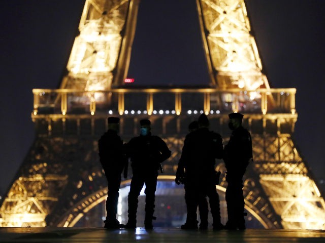 Police officers patrol on the Trocadero square near the Eiffel Tower during the New Year's Eve, in Paris, Thursday, Dec. 31, 2020. As the world says goodbye to 2020, there will be countdowns and live performances, but no massed jubilant crowds in traditional gathering spots like the Champs Elysees in …