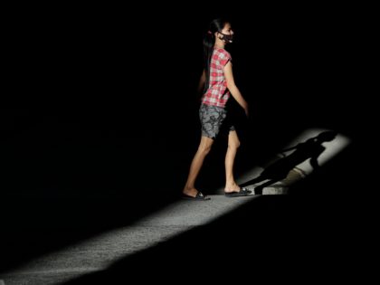 A woman wearing a protective mask walks along a street during enhanced community quarantine to prevent the spread of the new coronavirus in Manila, Philippines on Monday April 13, 2020. The new coronavirus causes mild or moderate symptoms for most people, but for some, especially older adults and people with …