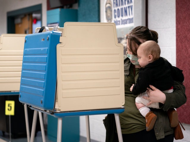 Six month old Henry watches as his mother fills out her ballot at an early voting center at the Mount Vernon Governmental Center on October 31, 2020 in Alexandria, Virginia. Today is the final day of early voting in Virginia, with voters waiting hours in line to cast their ballots …
