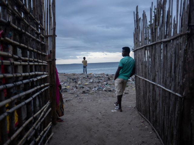 TOPSHOT - Men keep an eye on the sea at the port of the Paquitequete neighborhood where sa
