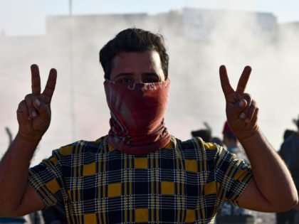 An anti-government protester gestures during a demonstration in front of the Dhi Qar Municipal council in Iraq's southern city of Nasiriyah on February 27, 2021, following the deadliest day in a week of violence in the city that left four anti-government protesters dead. - The day before, four protesters were …