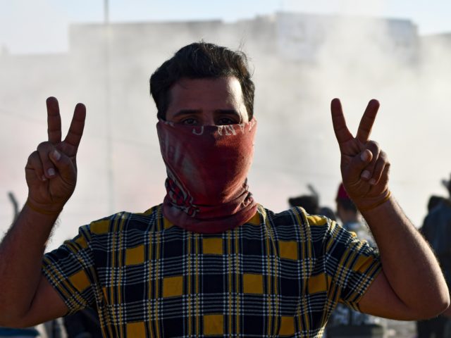 An anti-government protester gestures during a demonstration in front of the Dhi Qar Munic