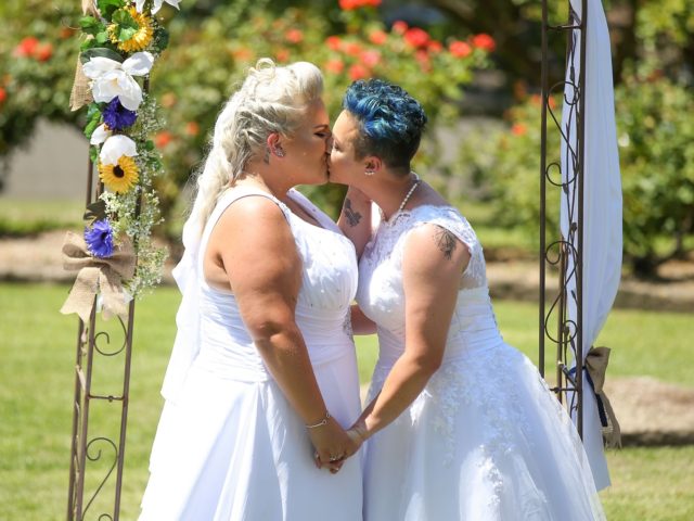 SYDNEY, AUSTRALIA - DECEMBER 16: Same-sex couple Amy Laker and Lauren Price kiss during their wedding ceremony on December 16, 2017 in Sydney, Australia. Lauren and Amy are the first gay couple to be legally married in Australia, after same-sex marriage was legalised on 9 December 2017. The women - …