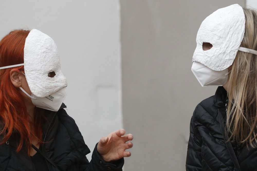 Participants talk before taking part in an Easter procession marching through the streets in Ceske Budejovice, Czech Republic, Thursday, April 1, 2021. The traditional event went ahead despite COVID-19 restrictions, although participants also wore medical face masks and observed social distancing as a precaution. (AP Photo/Petr David Josek)