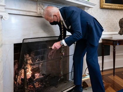 P20210122AS-0140: President Joe Biden adds a log to the fire in the Oval Office of the White House Friday, Jan 22, 2021. (Official White House Photo by Adam Schultz)