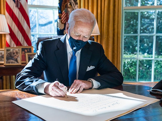 President Joe Biden signs a commission for Gina Raimondo as Secretary of Commerce Wednesda