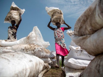 Women carry sacks of food, airdropped by the World Food Programme and distributed by the NGO Oxfam in Padding, near Lankien, Jonglei, South Sudan, on July 3, 2017. Fighting between Government and opposition forces in April 2017 pushed thousands of civilians to be displaced in Padding and Lankien, both are …