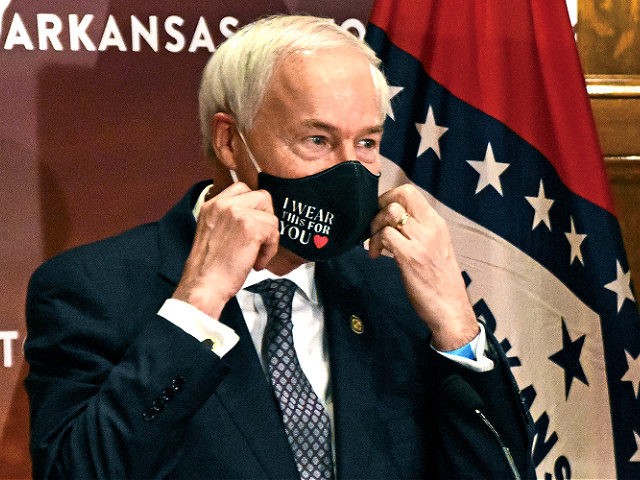 In this July 20, 2020 file photo, Arkansas Gov. Asa Hutchinson removes his mask before a briefing at the state capitol in Little Rock. Gov. Hutchinson on Monday, April 5, 2021 vetoed legislation that would have made his state the first to ban gender confirming treatments or surgery for transgender …