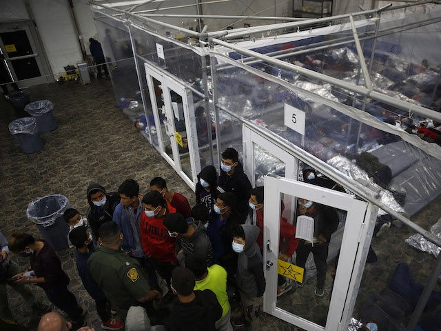 Young minors talk to an agent outside at a pod in the Donna Department of Homeland Security holding facility, the main detention center for unaccompanied children in the Rio Grande Valley run by the US Customs and Border Protection, (CBP), in Donna, Texas on March 30, 2021. - The minors …