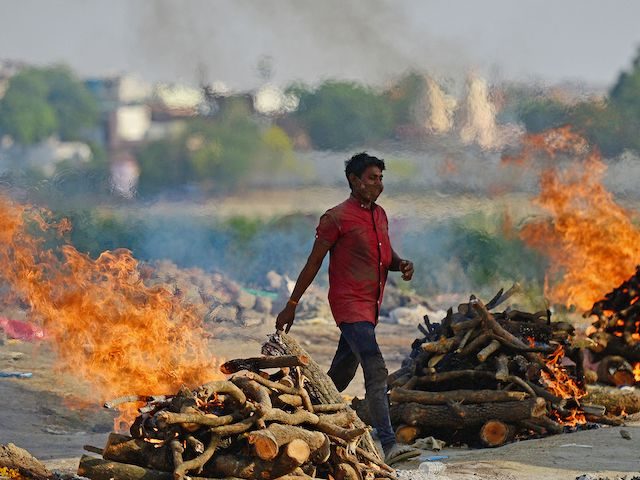 Funeral pyres burn as the last rites are performed of the patients who died of the Covid-19 coronavirus at a cremation ground in Allahabad on April 27, 2021. (Photo by SANJAY KANOJIA / AFP) (Photo by SANJAY KANOJIA/AFP via Getty Images)