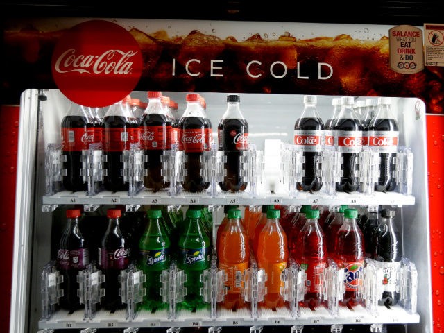 In this June 28, 2018, file photo, a Coca-Cola vending machine sits in the basement of the state Capitol as lawmakers debate a ban on local soda taxes, in Sacramento, Calif. Lawmakers passed the bill and Gov. Jerry Brown signed it into law, banning local soda taxes on soda for …