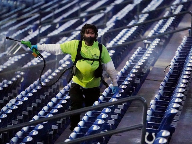 A stadium workers sprays disinfectant over the seats after a college basketball game between Baylor and Hartford in the first round of the NCAA tournament at Lucas Oil Stadium Friday, March 19, 2021, in Indianapolis. (AP Photo/Mark Humphrey)