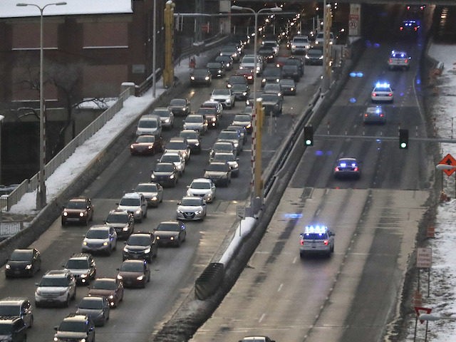Law enforcement vehicles, right, travel West on the Eisenhower Expressway as part of a pro