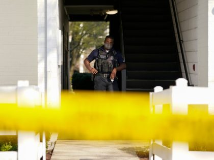 A police officer stands behind police tape outside the apartment of Navy Petty Ofc. 3rd Class Fantahun Girma Woldesenbet, assigned to Fort Detrick in Frederick, Md., Tuesday, April 6, 2021. Authorities say the Navy medic shot and wounded two U.S. sailors at a military facility before fleeing to a nearby …