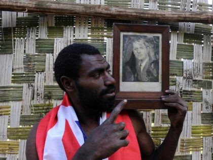 TO GO WITH AFP STORY "Vanuatu-Britain-religion-royals,FEATURE" by Madeleine Coorey Sikor Natuan, the son of the local chief, holds a water damaged portrait of Britain's Prince Philip in a partially built monument to the British royal near the remote village of Yaohnanen on Tanna in Vanuatu on August 6, 2010. In …