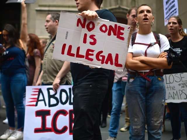 A protestor holds a sign reading No one is Illegal during a rally against the US immigration policy on September 14, 2019 in New York City. - Some dozens protesters were arrested by the police after blocking the 5th Avenue. (Photo by Johannes EISELE / AFP) (Photo credit should read …