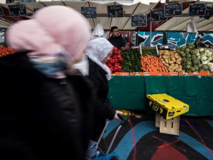 People do their grocery shopping at the Barbes Market, on March 18, 2020, in Paris, as a strict lockdown came into in effect in France to stop the spread of COVID-19, caused by the novel coronavirus. - A strict lockdown requiring most people in France to remain at home came …