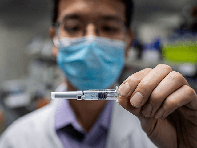 In this picture taken on April 29, 2020, an engineer shows an experimental vaccine for the COVID-19 coronavirus that was tested at the Quality Control Laboratory at the Sinovac Biotech facilities in Beijing. - Sinovac Biotech, which is conducting one of the four clinical trials that have been authorised in …