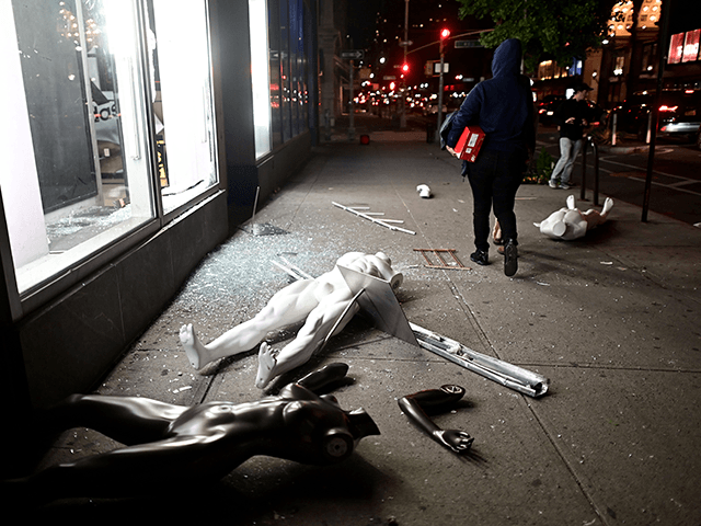 Looters walk next to a smashed store in Lower Manhattan on June 1, 2020, after a after dem