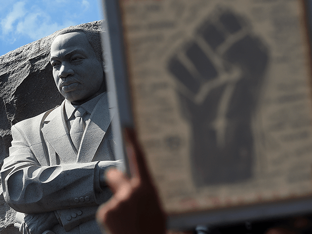 A statue of Martin Luther King Jr. is seen as demonstrators raise a fist image at The Martin Luther King Jr. Memorial to protest the death of George Floyd, who died in police custody in Minneapolis, in Washington, DC, on June 4, 2020. - On May 25, 2020, Floyd, a …