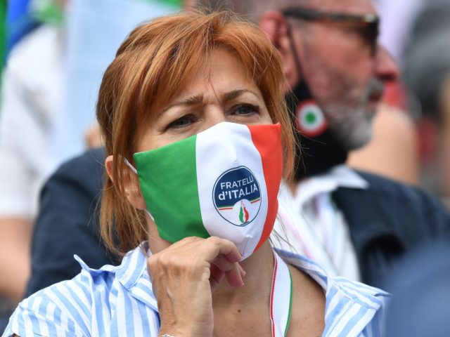 A woman wearing aface mask in the colors of the Italian flag, reading "Brothers of Italy" attends a united rally of the League (Lega) party, the Brothers of Italy (FdI) party and the Forza Italia (FI) party for a protest against the government on July 4, 2020 on Piazza del …